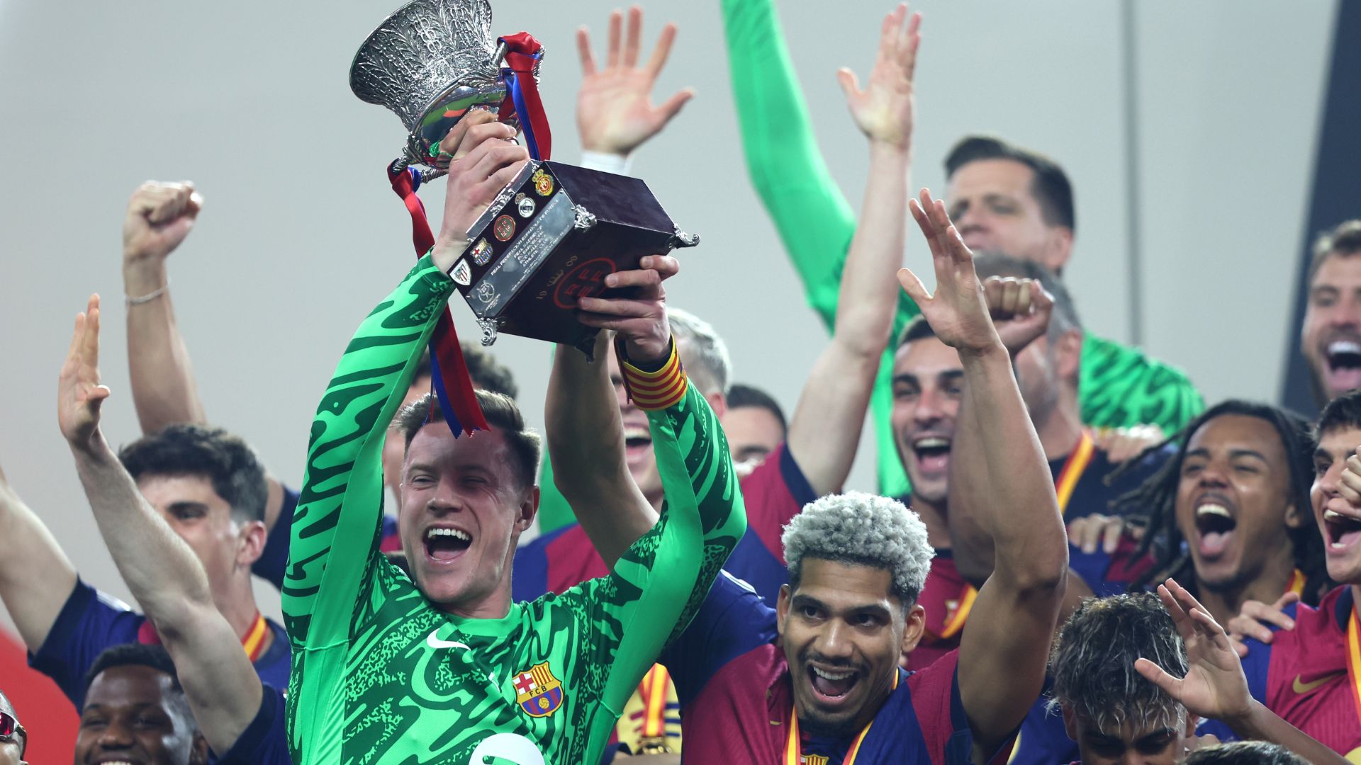 Inaki Pena and Ronald Araujo of FC Barcelona celebrate with the Supercopa de Espana trophy 2025