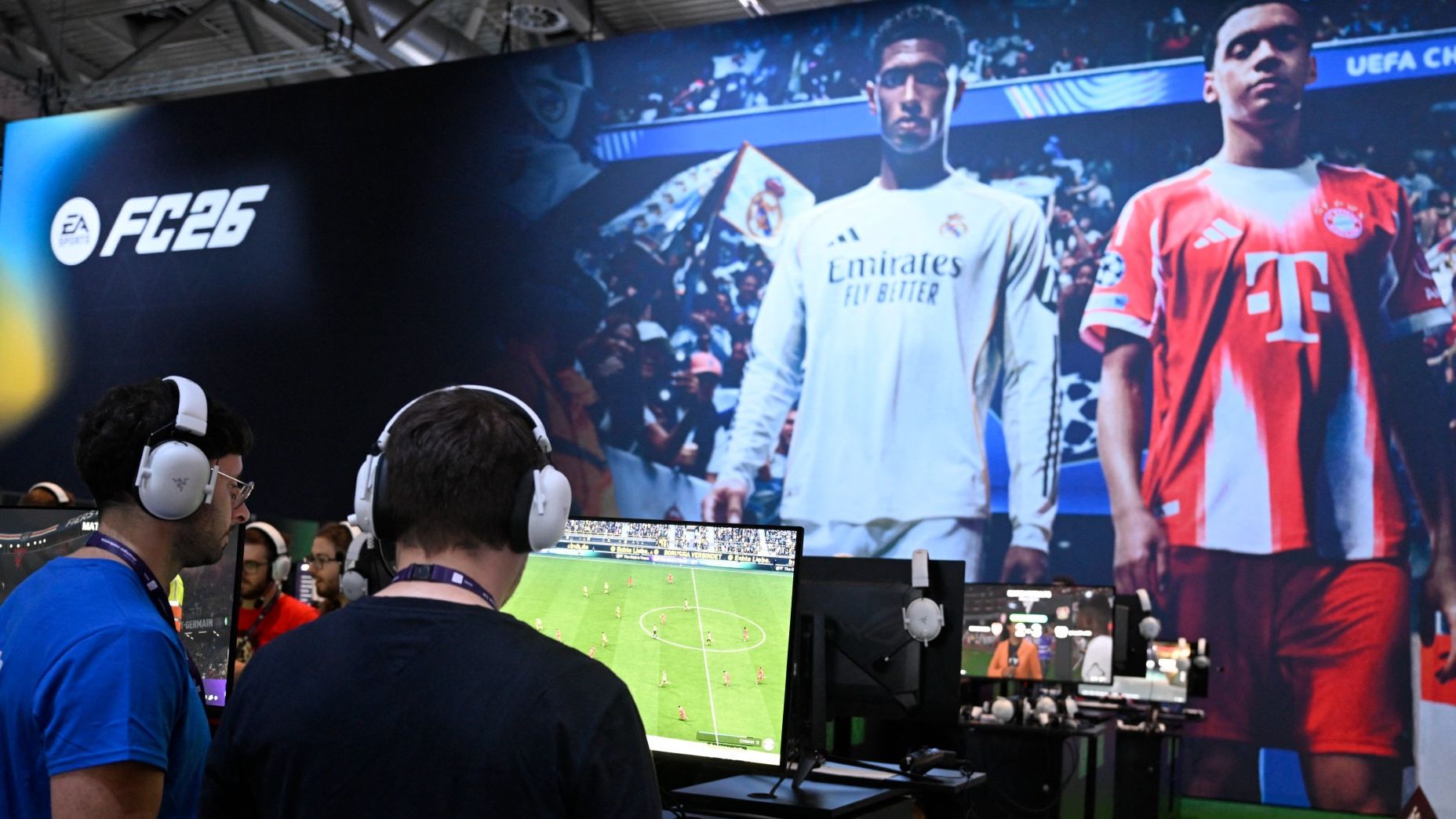Gamers play the video game EA Sports FC 26 in front of a screen