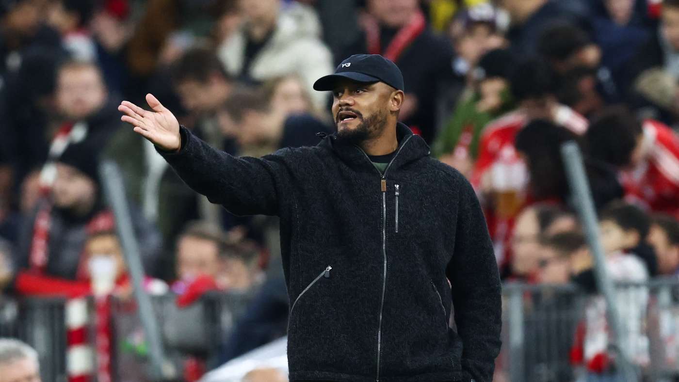 Vincent Kompany parla durante la conferenza stampa Bayern-Colonia; Neuer resta in ascolto