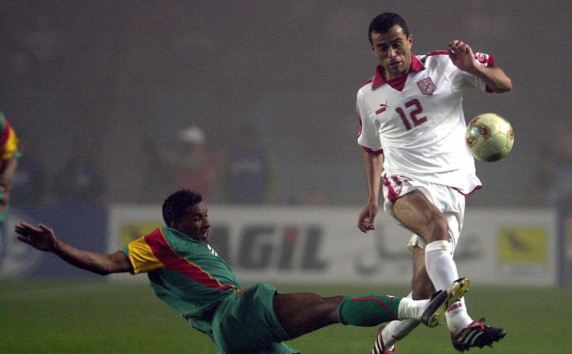 Tunisia's Jawhar Mnari (L) jumps over a 
