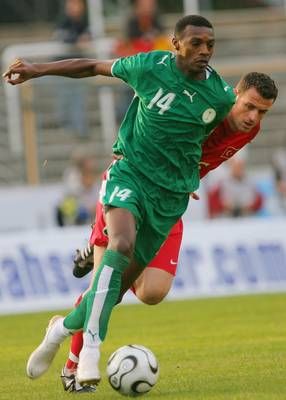 لاعب تركي يحاول مضايقة لاعب الوسط السعودي سعود كريري
