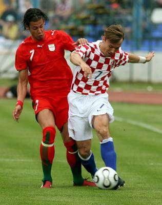 الايراني زاندي ( يسار ) مع الكرواتي ستروجلس ( يمين ) في صراع على الكرة