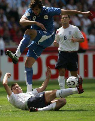 روكي سانتا كروز مهاجم الباراغواي في مضايقة مع ستيفين جيرارد الانجليزي