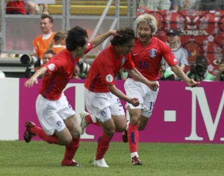 الكوري آهن يونغ-هوان (وسط) يحتفل مع رفاقه بأحرازه للهدف الثانى في مرمى توجو