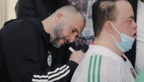 جمال بلماضي يوقع لأحد الأطفال على قميص الجزائر