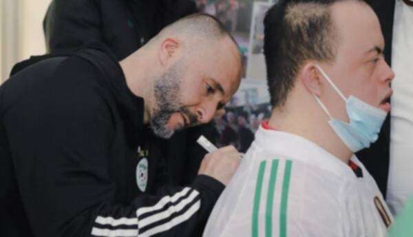 جمال بلماضي يوقع لأحد الأطفال على قميص الجزائر