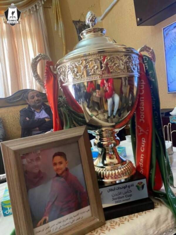 كأس البطولة الي جانب صورة الطفل الراحل