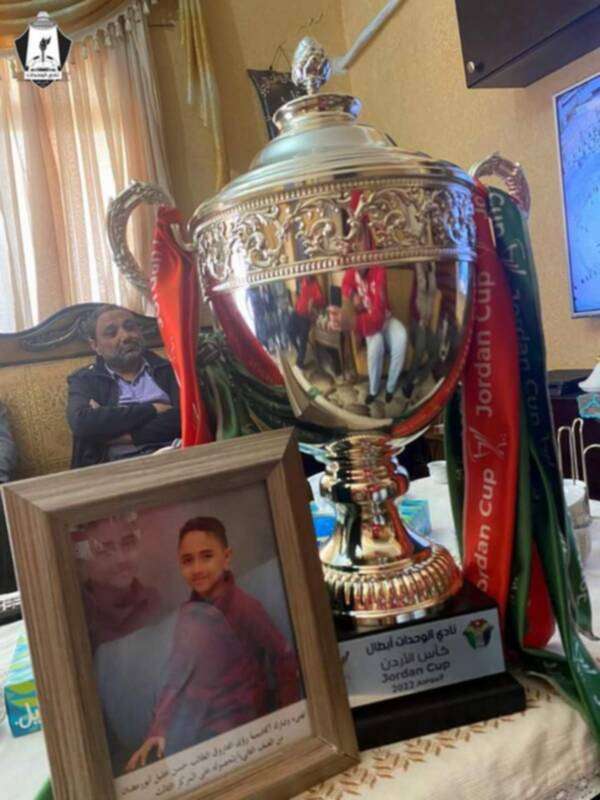 كأس البطولة الي جانب صورة الطفل الراحل