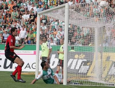 هوجو الميدا لاعب بريمن يسجل 2-1 امام لاعب بايرليفركوزن احمد مادوني (اليسار)