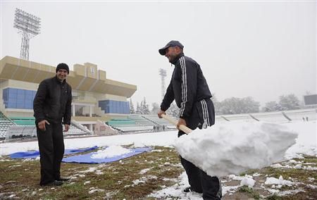 عمال يحاولون تنظيف الملعب بعد ظهور شكوى اليابانيين