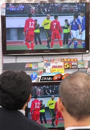 الجماهير اليابانية تتابع المباراة من شاشات التلفاز بطوكيو