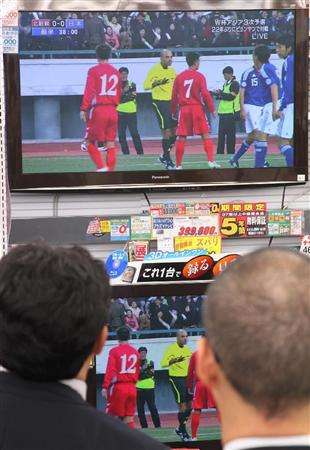 الجماهير اليابانية تتابع المباراة من شاشات التلفاز بطوكيو