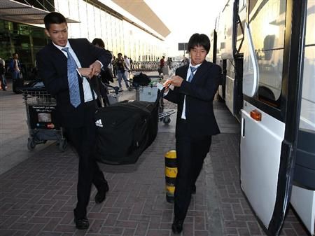 لاعبو اليابان يحملون الحقائب قبل ذهابهم للفندق بقطر