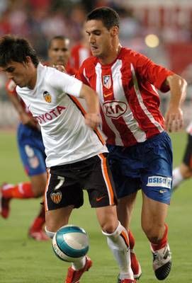 ديفيد فيا صاحب هدف مبارة فالنسيا مع اتلتيكو مدريد الوحيد يراوغ لاعب اتلتيكو مدريد