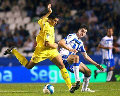 مدافع لاكورونا اريزماندي (اليمين) يحاول استخلاص الكرة من بين اقدام لاعب فياريال ريكيلمي