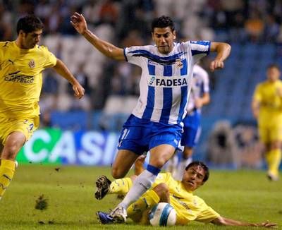 مهاجم لاكورونا ريكي (في الوسط) في صراع على الكرة مع مدافع فياريال فينتا 