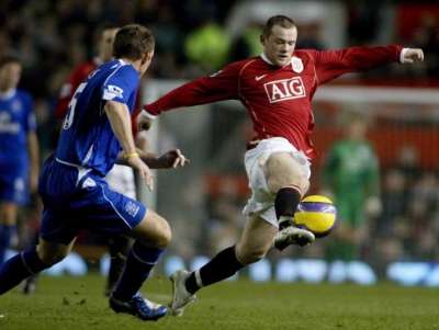 واين روني لاعب مانشيستر يونايتد يسيطر على الكرة أمام لاعب ايفرتون ستوبز