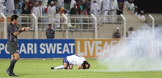 لاعب الوسط هان كوك يونج يتألم بعد تعرضه لمفرقعات نارية من قبل بعض الجماهير العمانية