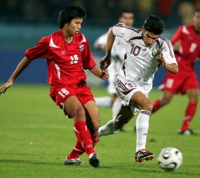 لاعب منتخب تايلند هاتهايراتانكول (الى اليسار) ولاعب قطر حسين ياسر في لقطة من مباراة الفريقين
