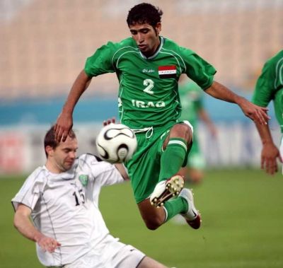 لاعب منتخب العراق محمد علي كريم يقطع الكرة من امام مهاجم اوزبكستان الكسندر جينريخ