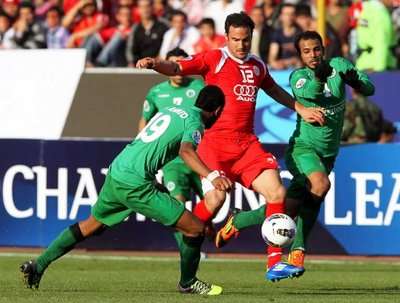 ايمن زايد يحاول المرور بين لاعبين من فريق الشباب الأماراتى 