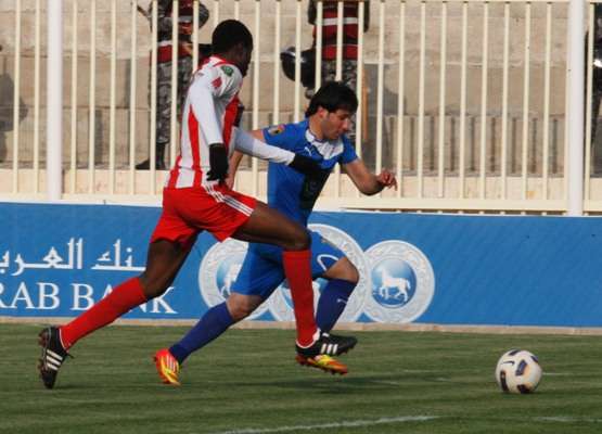 اللحام لاعب الرمثا يتوغل وسط مطاردة مدافع شباب الأردن أحمد محمد