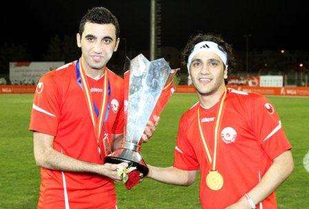 سلمان "يمين: ومحمد مصطفى "يسار" يحتفلان بكأس إحدى البطولات مع المحرق