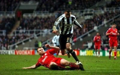 لاعب ليفربول جون أرني رييسة يحاول تخليص الكرة من لاعب نيوكاسيل كيرون داير