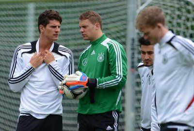 اللاعب جوميز يتحدث مع الحارس مانويل نيور في تدريب ألمانيا أمس والقلق يبدو واضحا عليهما 