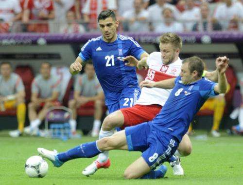 بابادوبولوس يتدخل في كرة مشتركة على أحد لاعبي بولندا