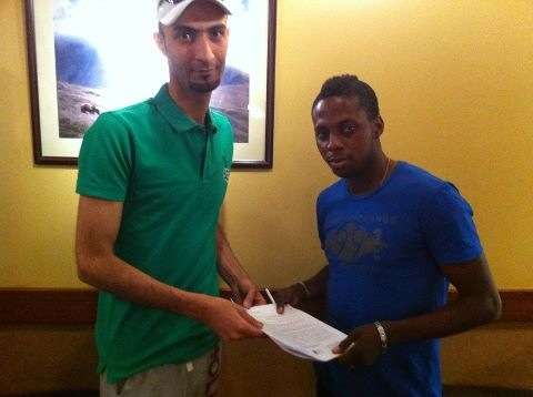 عبدالله فتاي ( يمين ) لحظة توقيعه للشعلة 