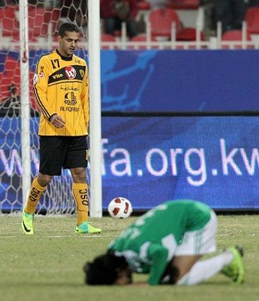فرحة علي مقصيد لاعب العربي بالفوز على القادسية ويبدو بدر المطوع حزينا