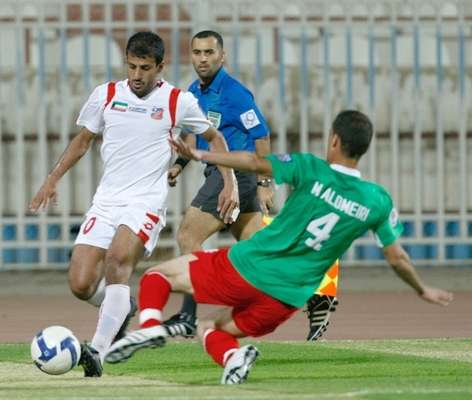 حسين حاكم لاعب الكويت يمر من مدافع الوحدات