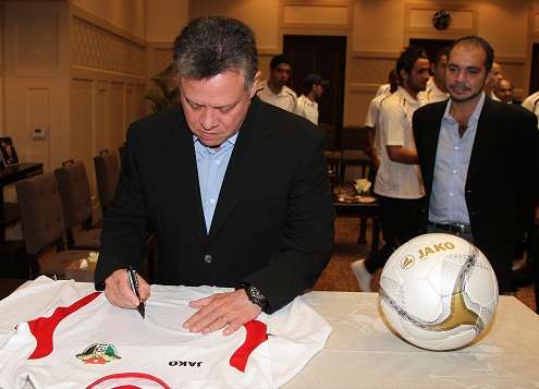 الملك عبدالله الثاني يوقع على قميص النشامى خلال استقباله للمنتخب