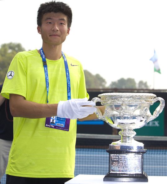 اللاعب الصيني المغمور وبجواره كأس البطولة 