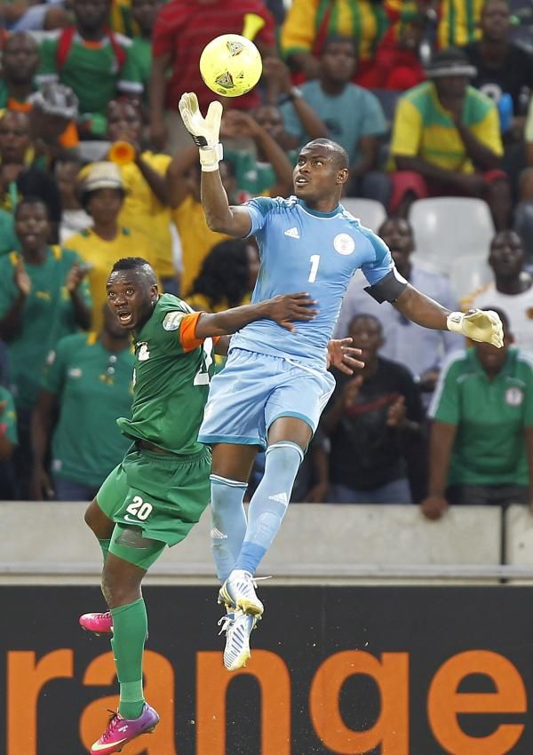  إينياما حارس نيجيريا يلتقط الكرة قبل مهاجم زامبيا 