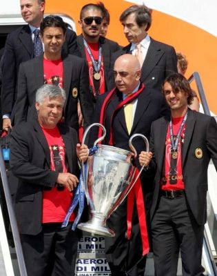 أنشيلوتي و باولو مالديني يحملان الكأس أثناء نزولهم من الطائرة