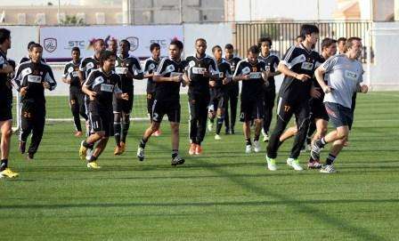 لاعبو الشباب يؤدون حركات الأحماء قبل تدريب اليوم