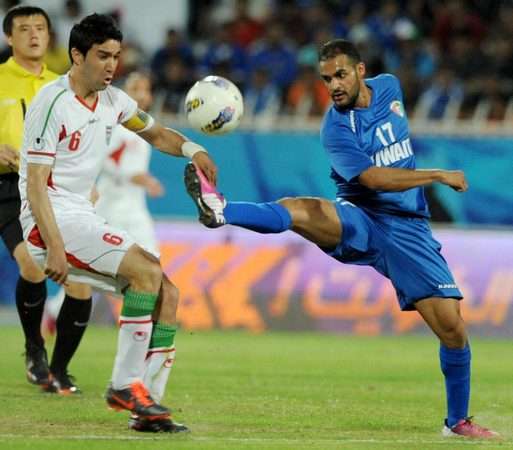بدر المطوع في صراع على الكرة مع الإيراني جواد نيكونام أمس 