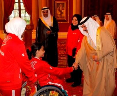 يصافح إحدى بطلات ذوي الاحتياجات الخاصة 