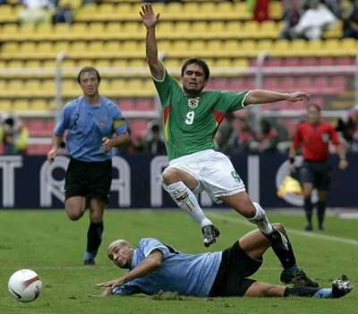 المدافع أوروغواي كارلوس دييغو يحاول إيقاف تقدم المهاجم البوليفي جيم مورينو