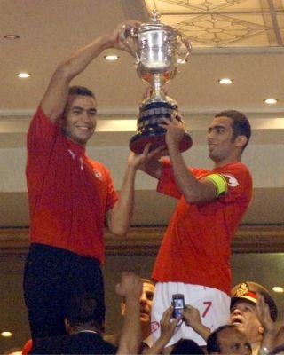 قائد الأهلي شادي محمد يحمل كأس البطولة ومعه الحارس عصام الحضري