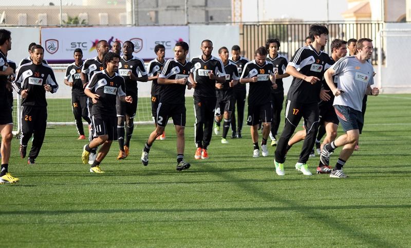 لاعبو الشباب يؤدون حركات الأحماء قبل تدريب اليوم