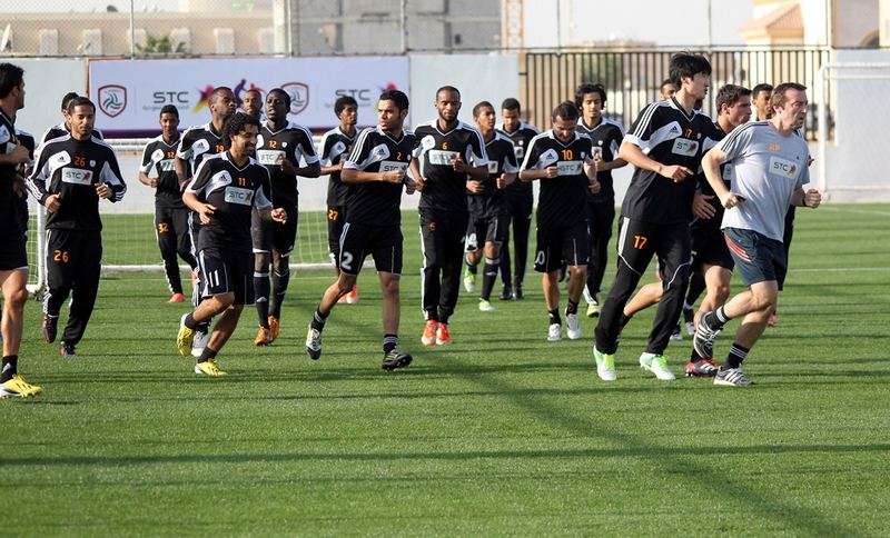 لاعبو الشباب يؤدون حركات الأحماء قبل تدريب اليوم