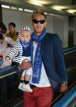 كيسوكي هوندا عند وصوله لمطار ناريتا مع الطفل 