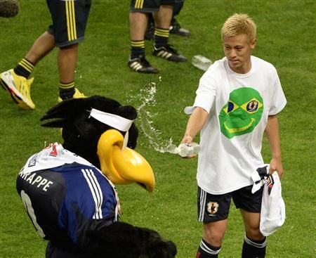 هوندا يمازح تميمة المنتخب الياباني بعد نهاية المباراة والإحتفال بالتأهل