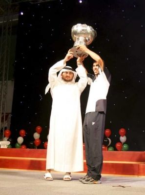 الشيخ مكتوم بن محمد بن راشد وقائد المنتخب العراقي يونس محمود يرفعان كأس آسيا