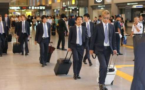 كيسوكي هوندا برفقة زملائه في مطار ناريتا بعد عودتهم من البرازيل