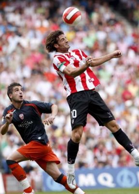 لاعب اتليتيكو بلباو أوسيو يضرب الكرة برأسه من امام لاعب اوساسونا بورتيللو