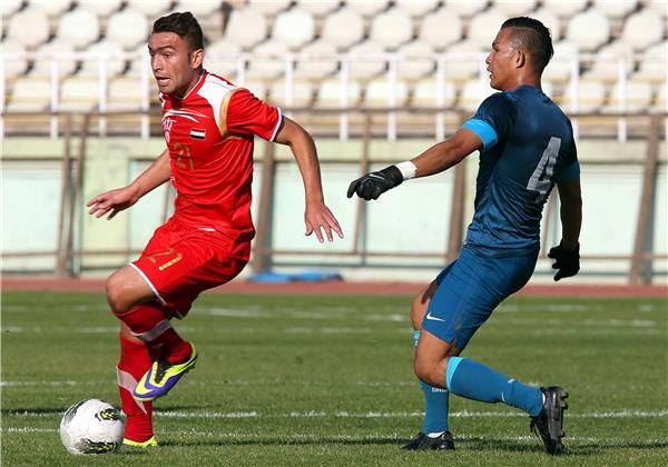 حميد ميدو في صراع على الكرة مع لاعب سنغافوري